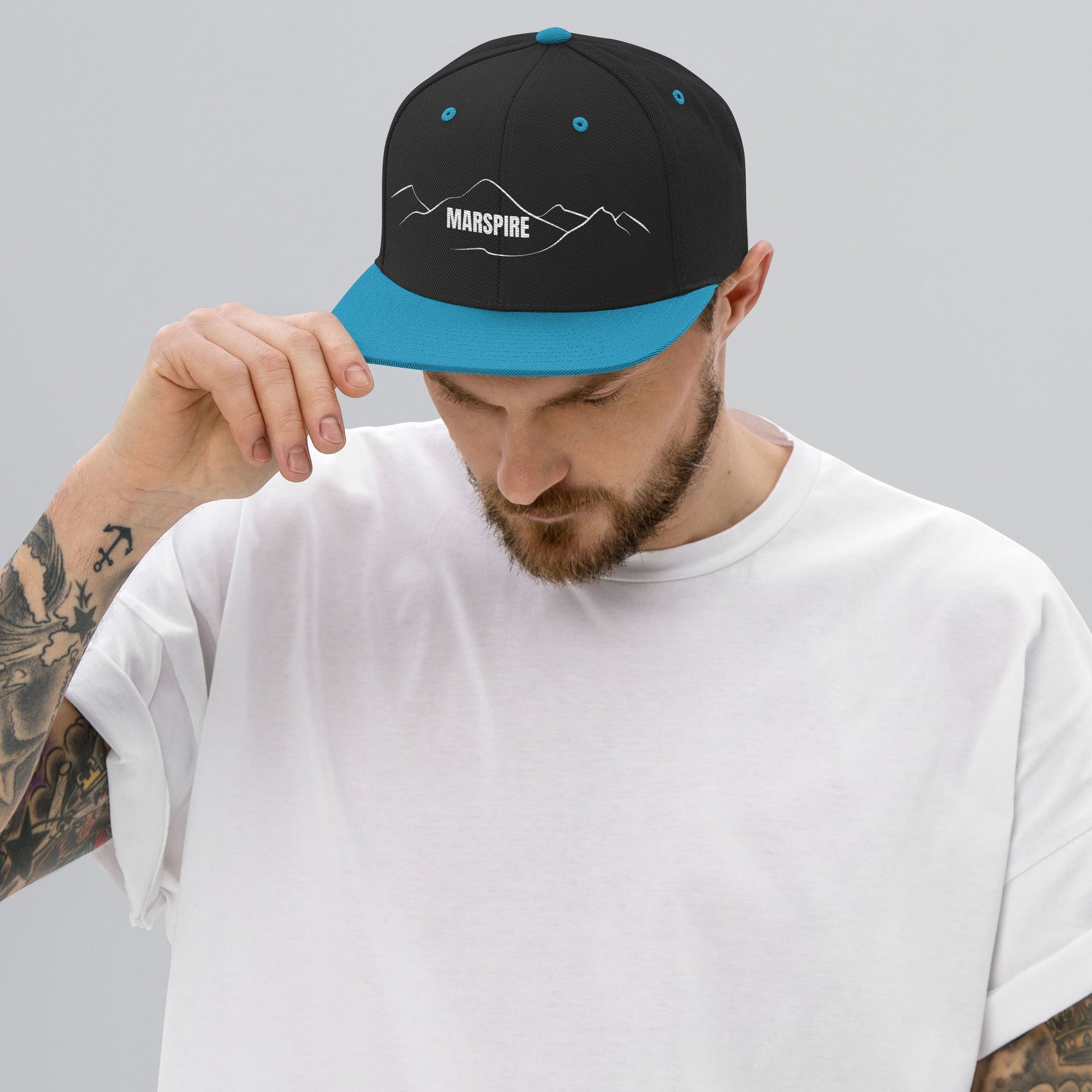 person wearing black & teal vintage snapback hat