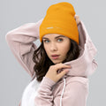 person wearing gold beanie hat
