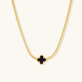 Dainty 18K gold-plated herringbone chain necklace with black enamel quatrefoil clover pendant on white background