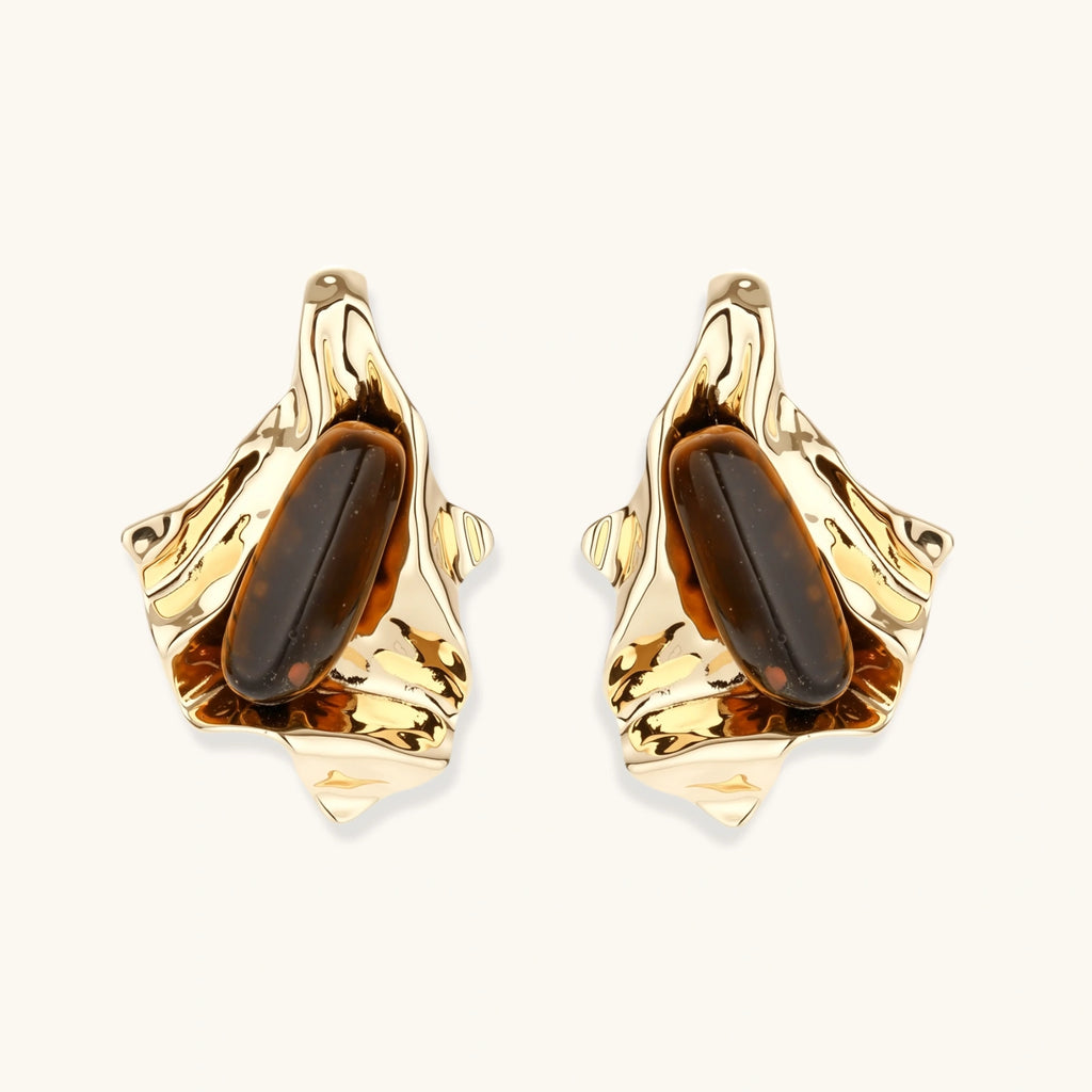 Sculptural stud earrings with organic twisted metal design holding brown gemstones, shown in gold and silver finishes.